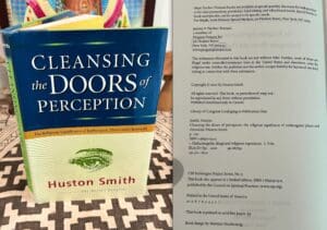 Book titled 'Cleansing the Doors of Perception' by Huston Smith beside typed document.